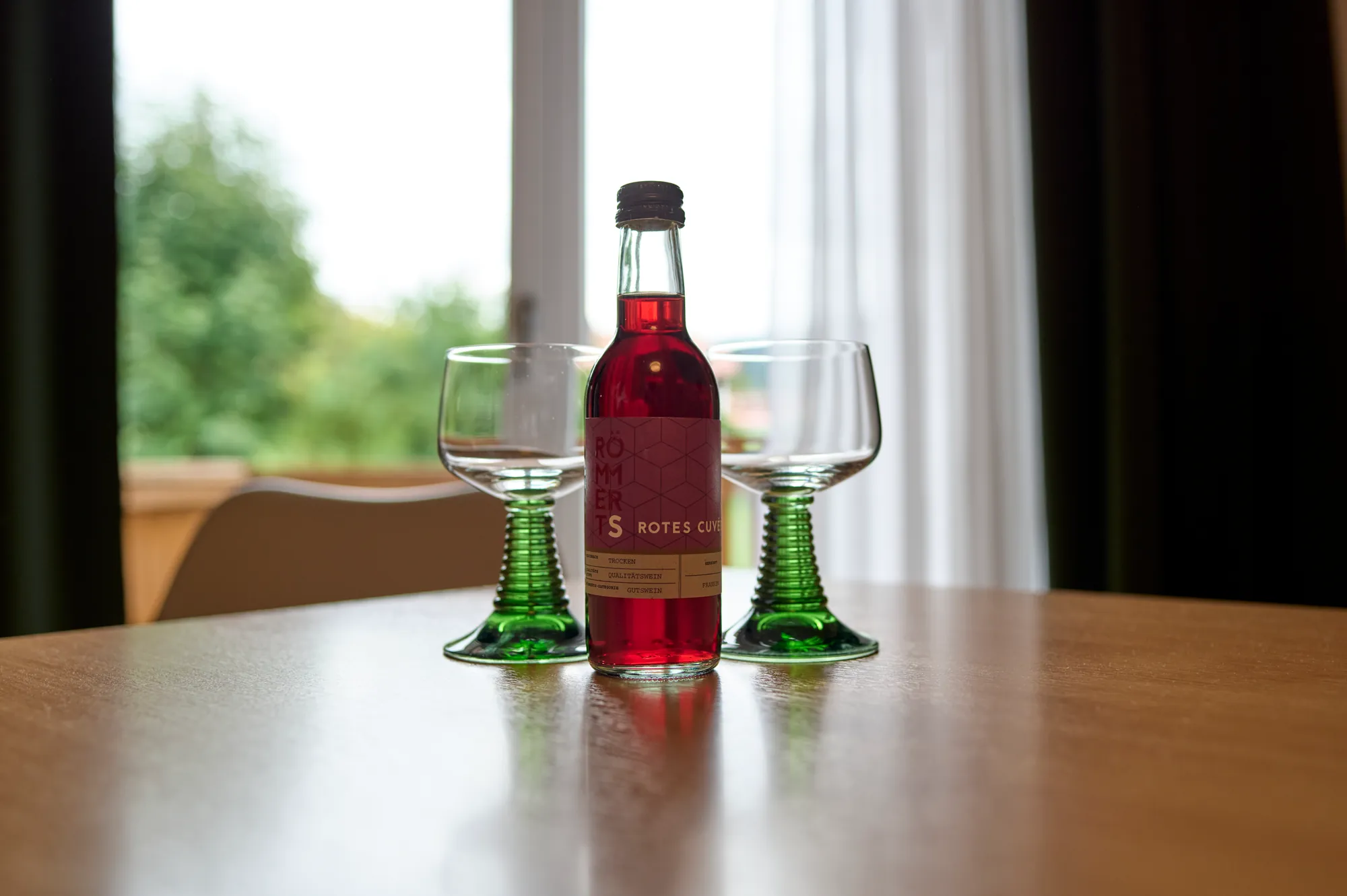 Flasche und Glaeser am Fenster einer Ferienwohnung