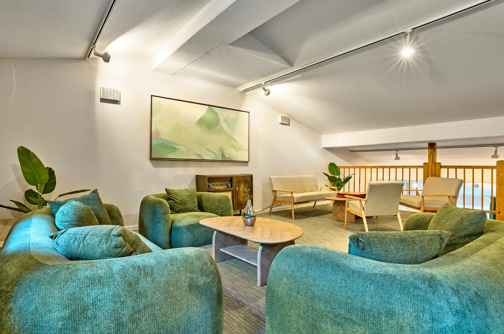 Gemeinschaftslounge mit tuerkisen Sitzgruppen
